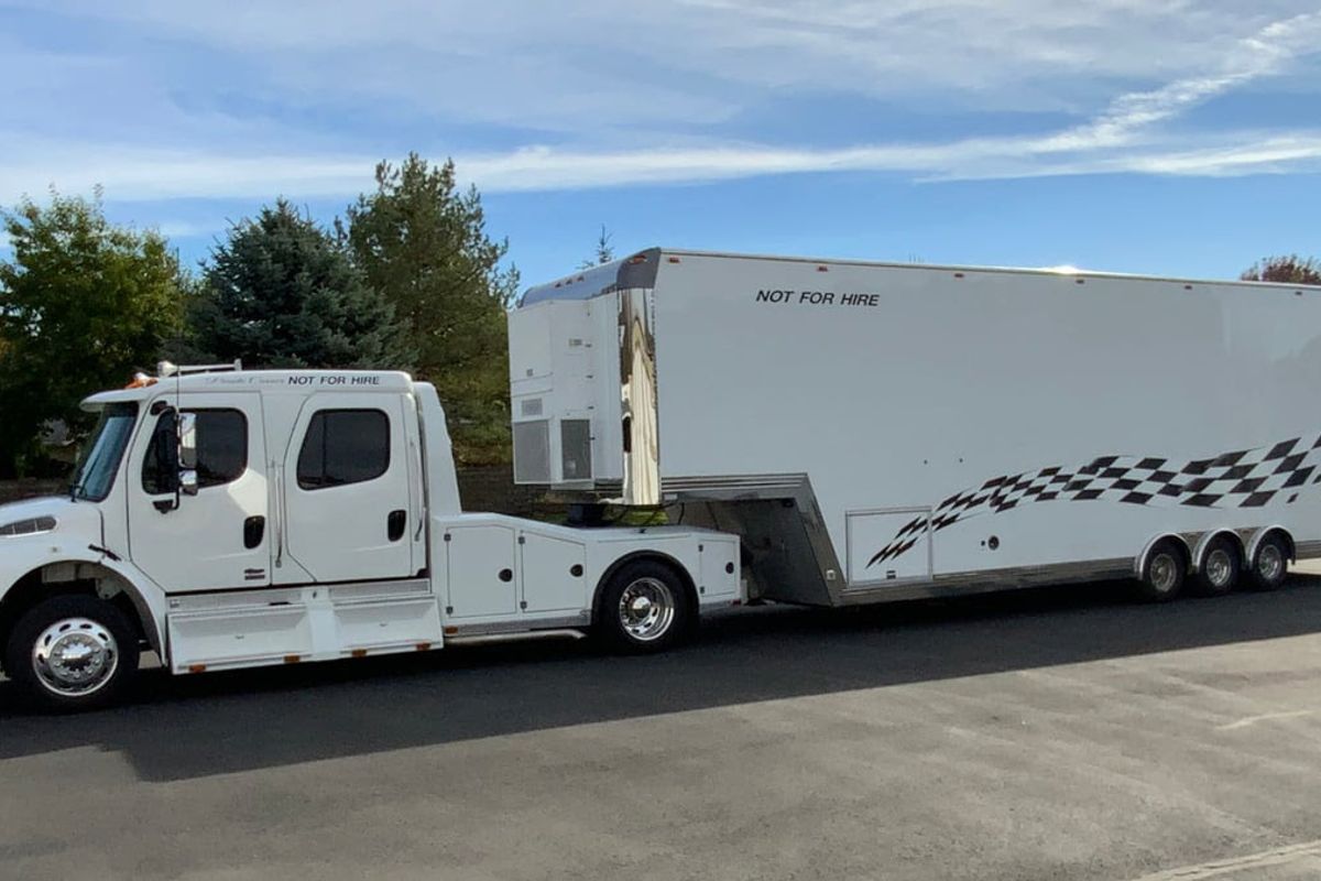 Freightliner 16M Sport Chassis Truck with CGXP 40' Stacker Trailer hauling to Mecum